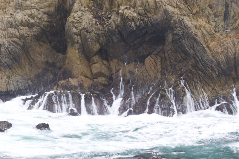 Waves Breaking Against Cliff Face